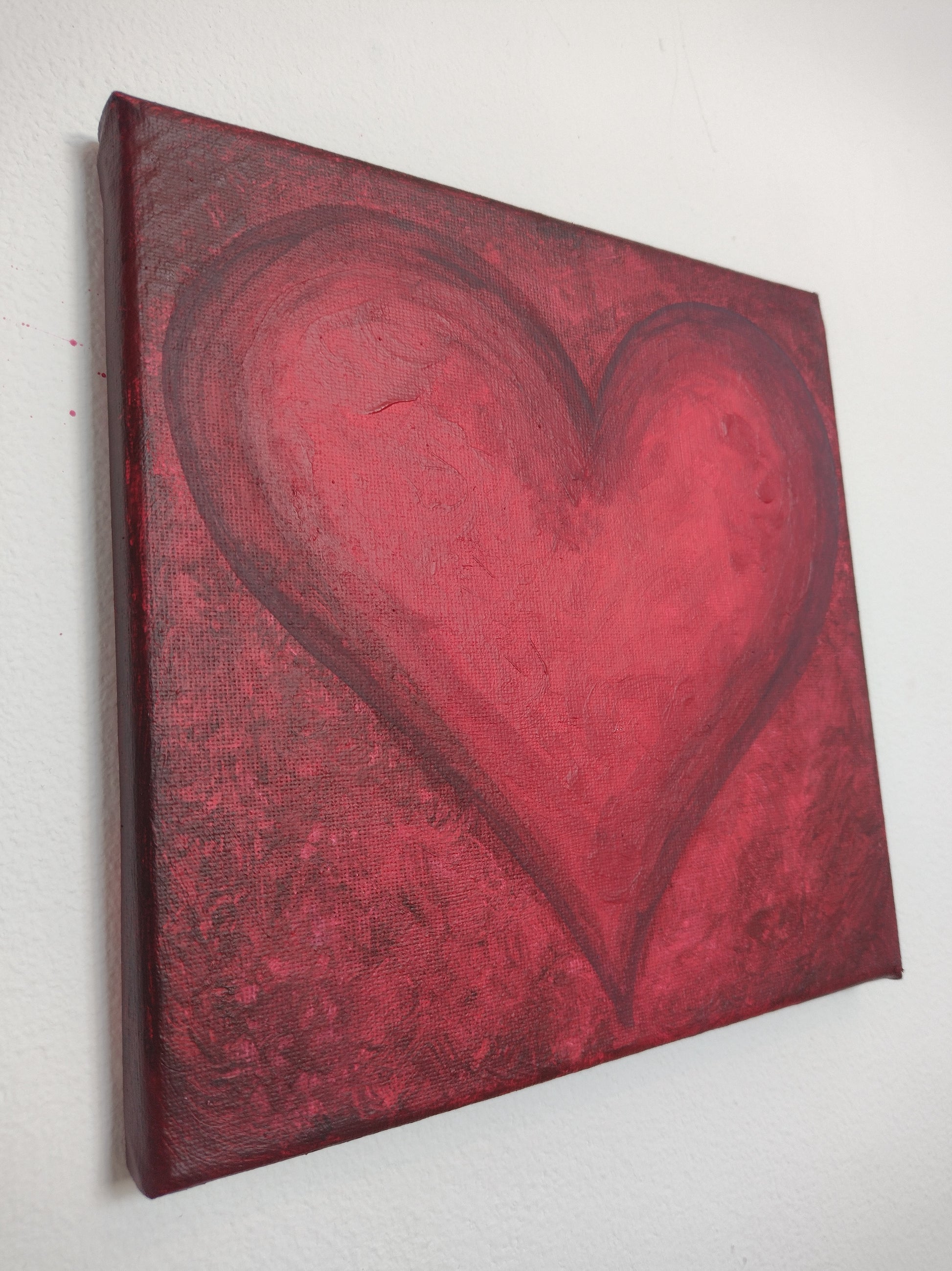 Colour image of angle view of Forever Love, original acrylic painting on canvas 20cm x 20cm red heart on red background 