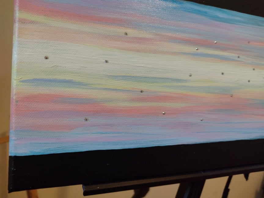 Close-up side view photo of 'Heavenly Sky' Original acrylic on canvas painting by Kathryn Mason. Embellished with Swarovski crystals  in abstract style with pastel mid and black top and bottom stripes. 